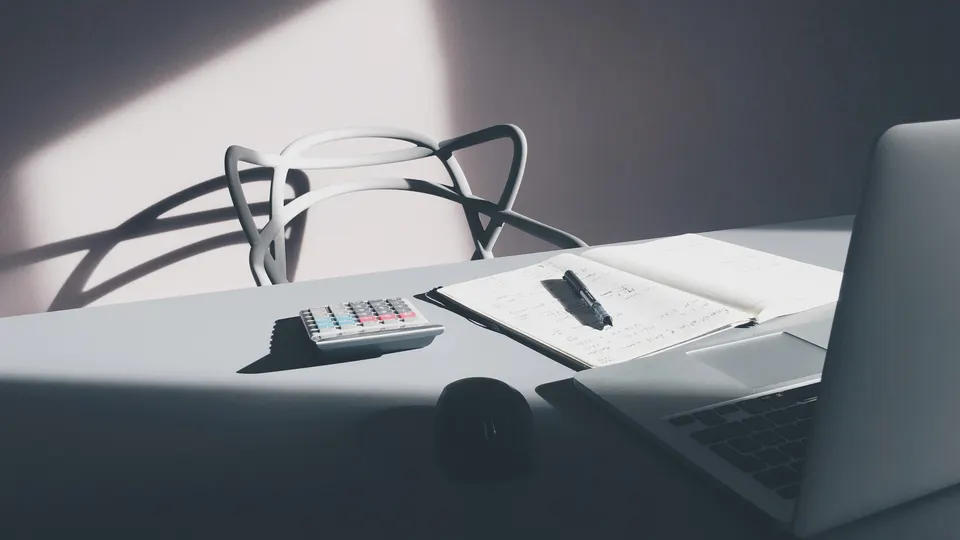 Desk with calculator and laptop